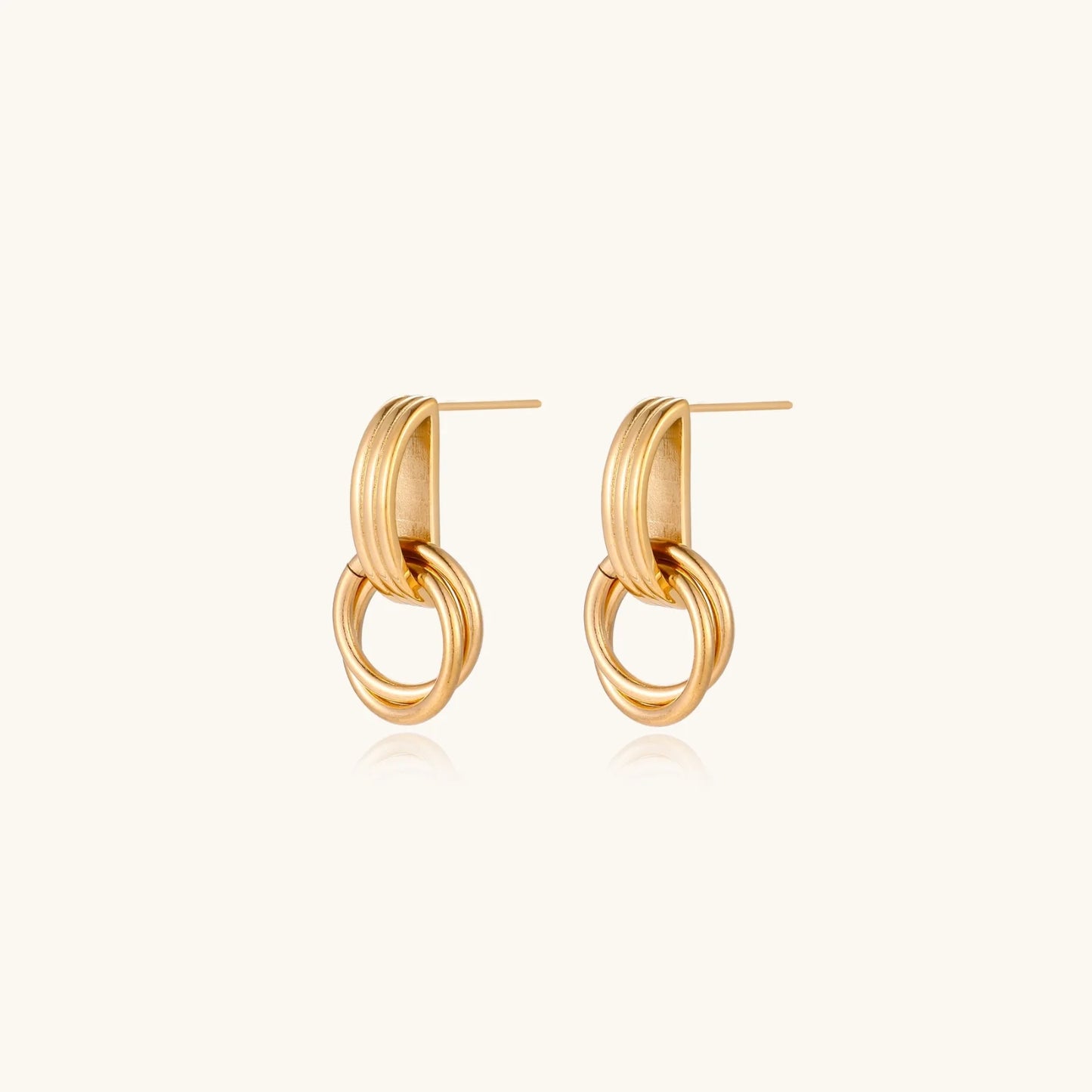 Gold stud earrings with vertical ridged bar connecting to triple interlocking circular rings on white background